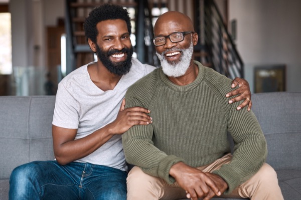 Son and dad smiling in camera. 